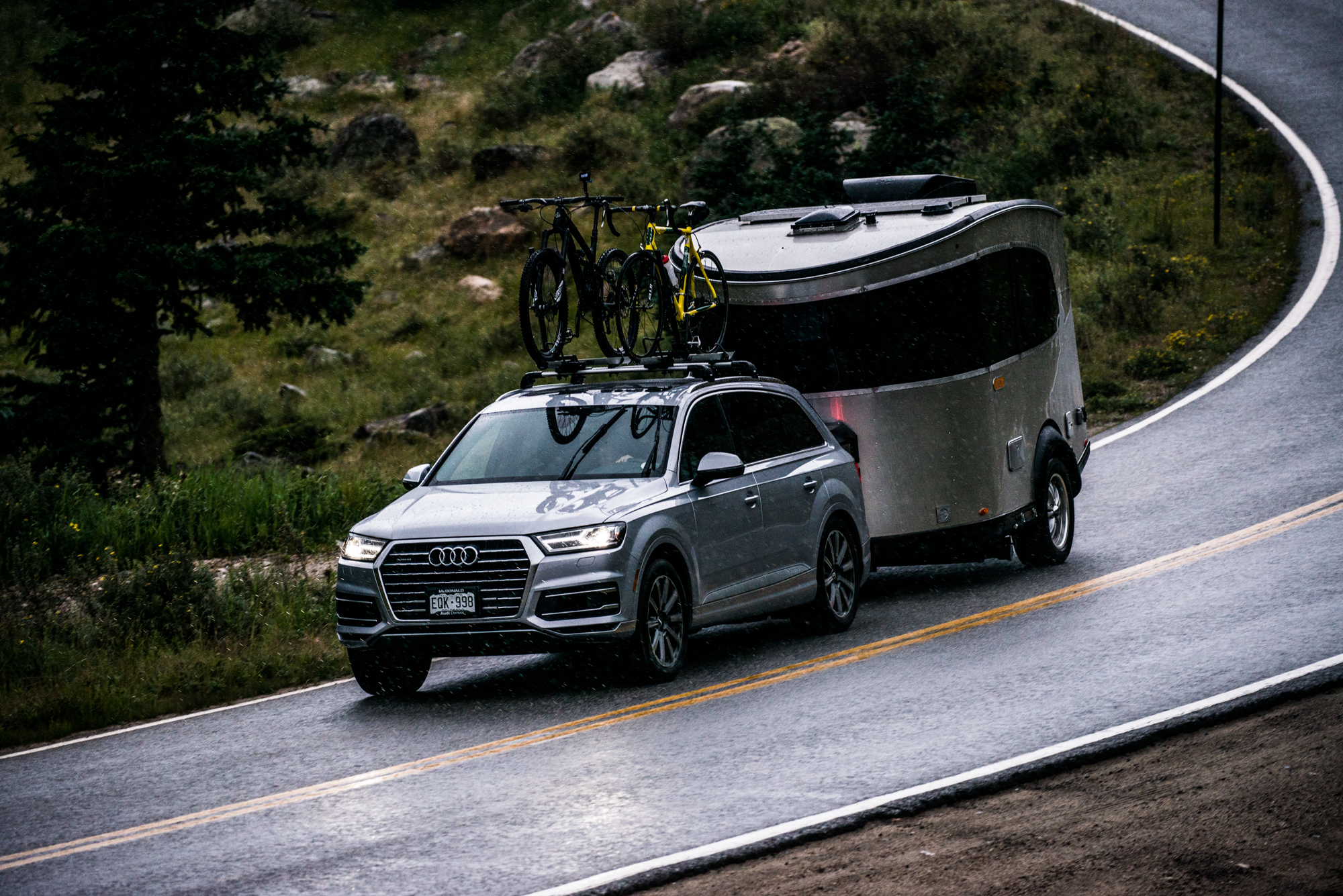 Airstream towed on a mountain road with bikes on the roof rack