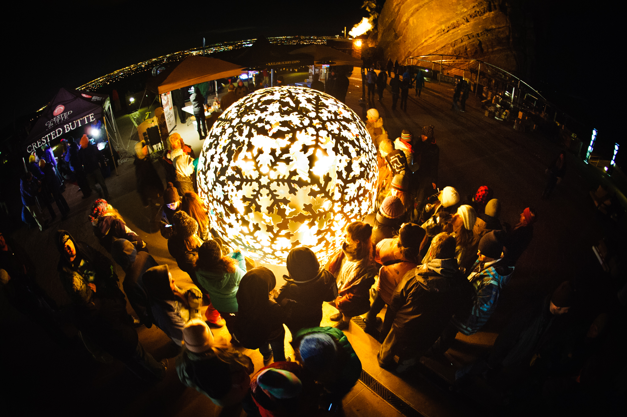 Illuminated laser-cut orb sculpture at a night event