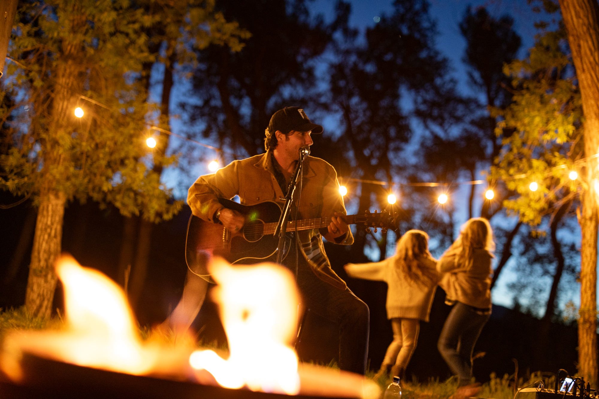 Intimate acoustic set by a firepit under string lights