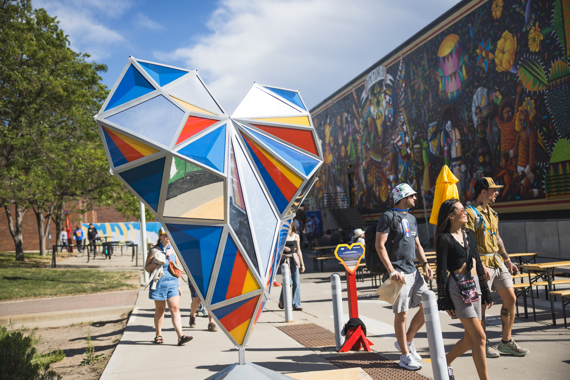 Faceted stained-glass heart sculpture at an outdoor festival