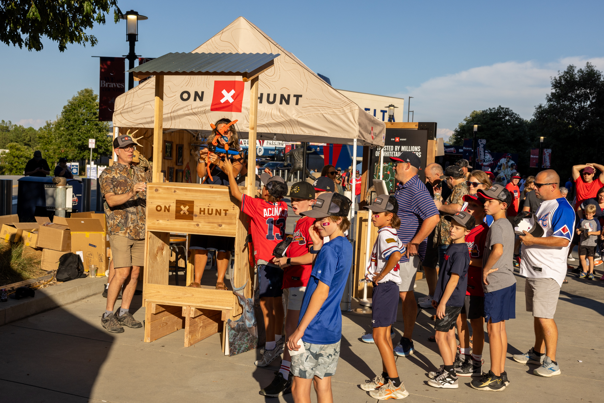 Custom-built onX Hunt activation booth with a crowd at the ballpark