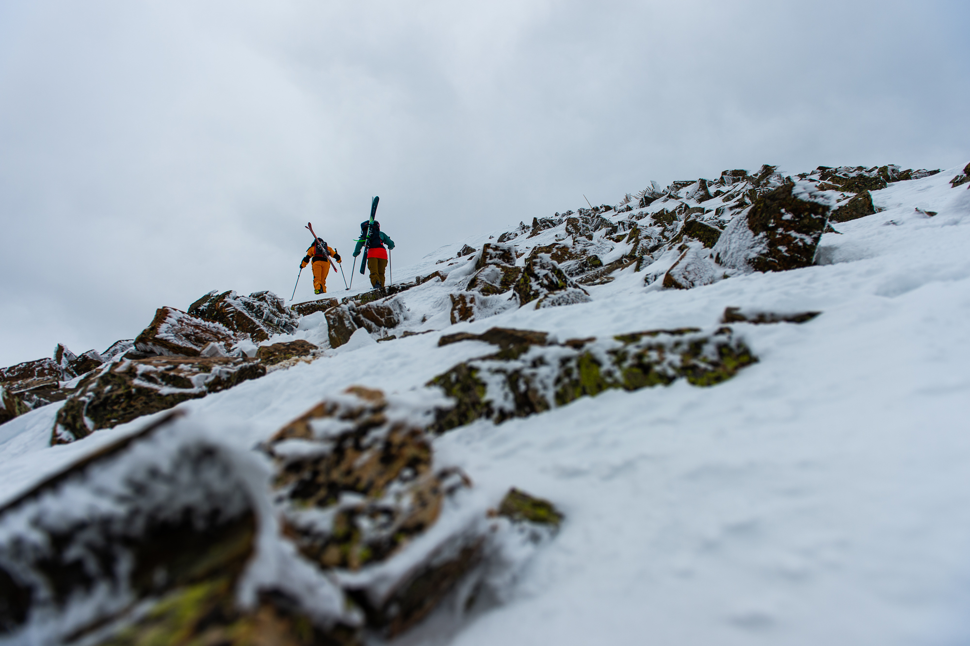 Two ski mountaineers climbing a snowy alpine ridge