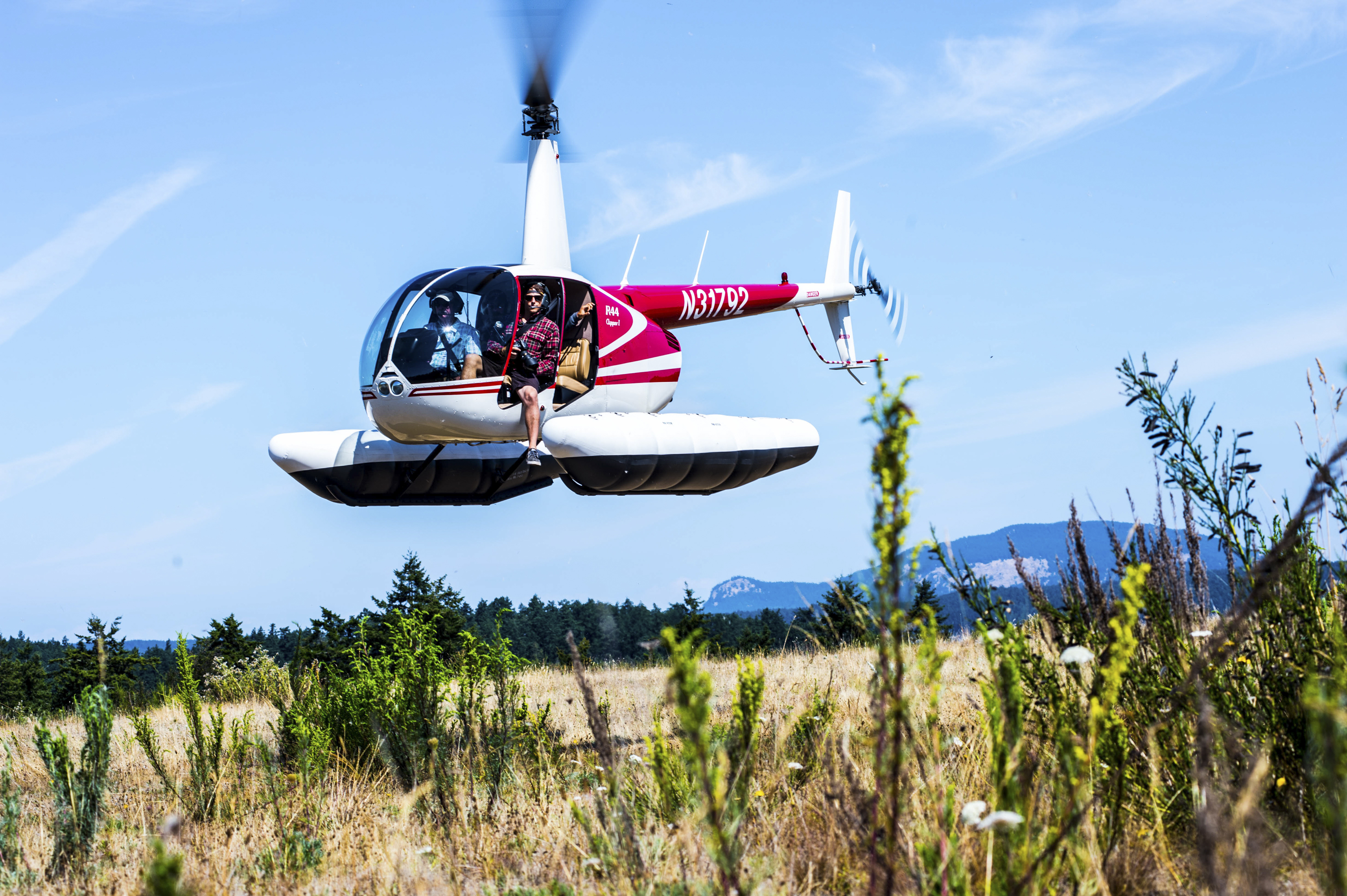 Helicopter lifting off from a summer coastal meadow