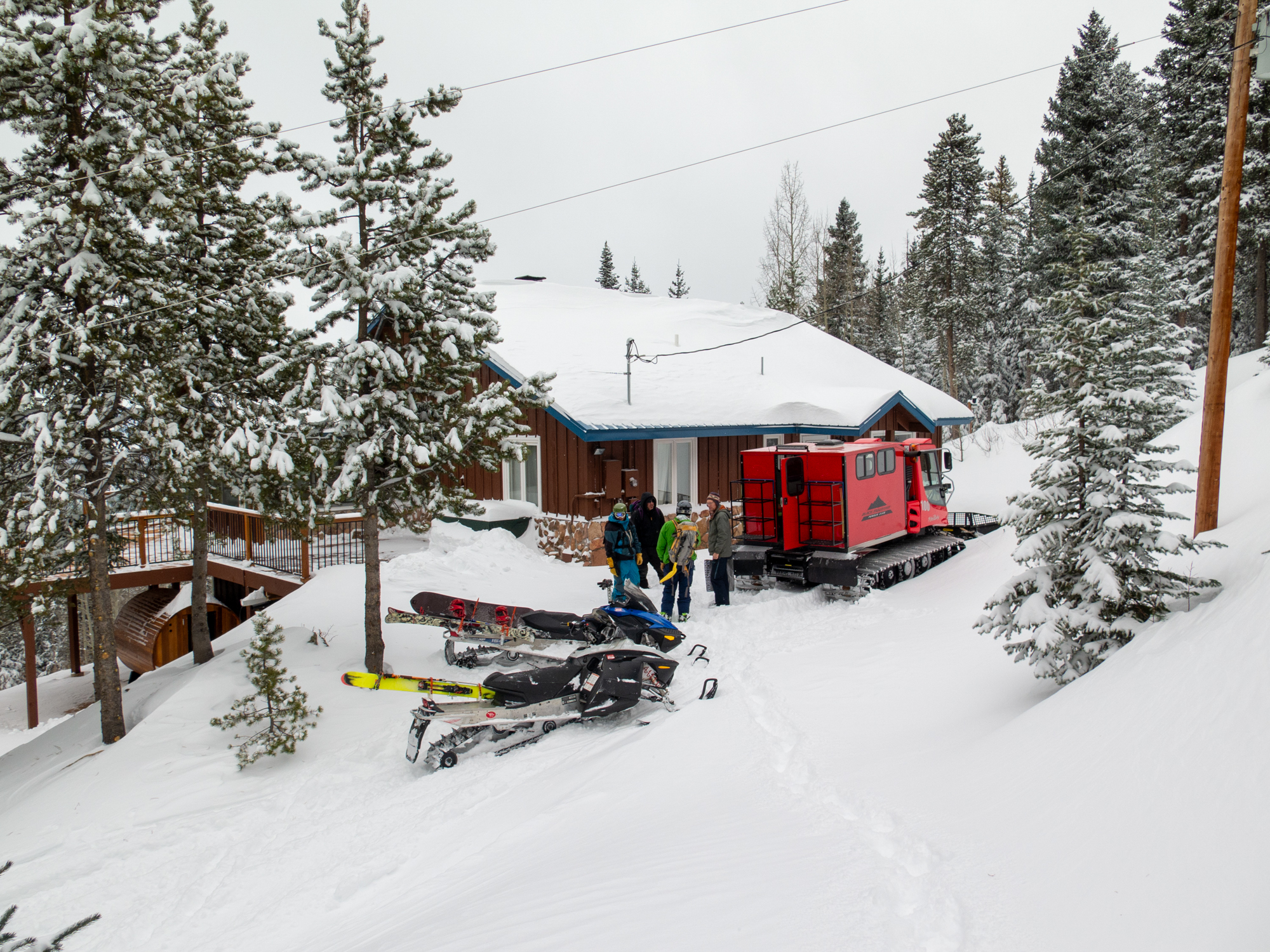 Snowcat and snowmobiles staged outside the lodge